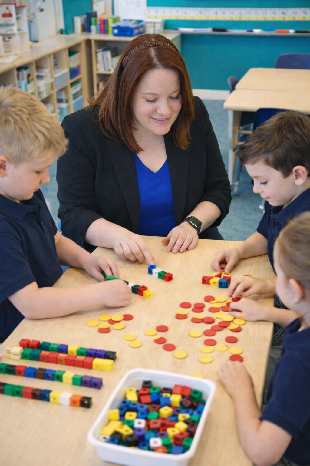 Teacher and students engaged in a math activity with colorful blocks in a classroom setting.